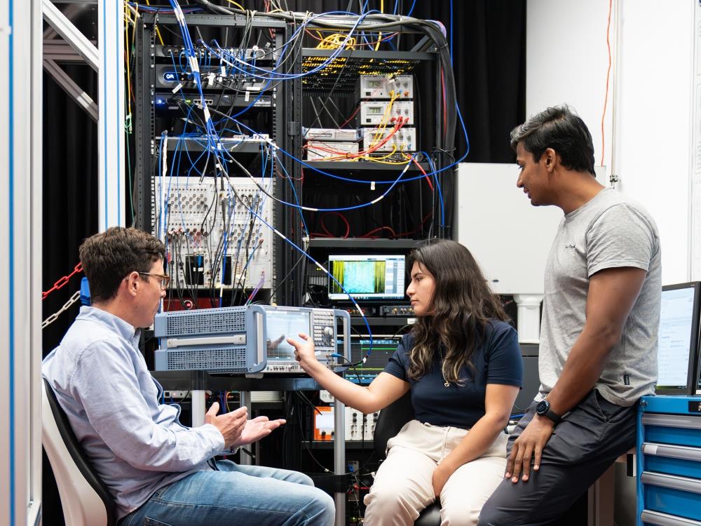 Professor Johannes Fink, Doktorandin Jennifer Sanchez Naranjo und Postdoc Rishabh Sahu diskutieren im Labor der Fink Gruppe am ISTA.