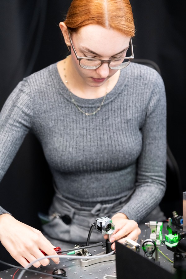 Andrea Stöllner sorgt auf einem Anti-Vibrationstisch für die richtige Ausrichtung von Laserstrahlen, Spiegeln und Kameras.