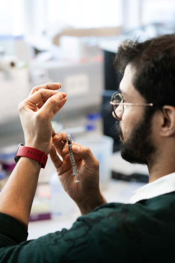 Suyash Naik prepares the syringe he will use to transfer the embryos into a petri dish under the microscope.